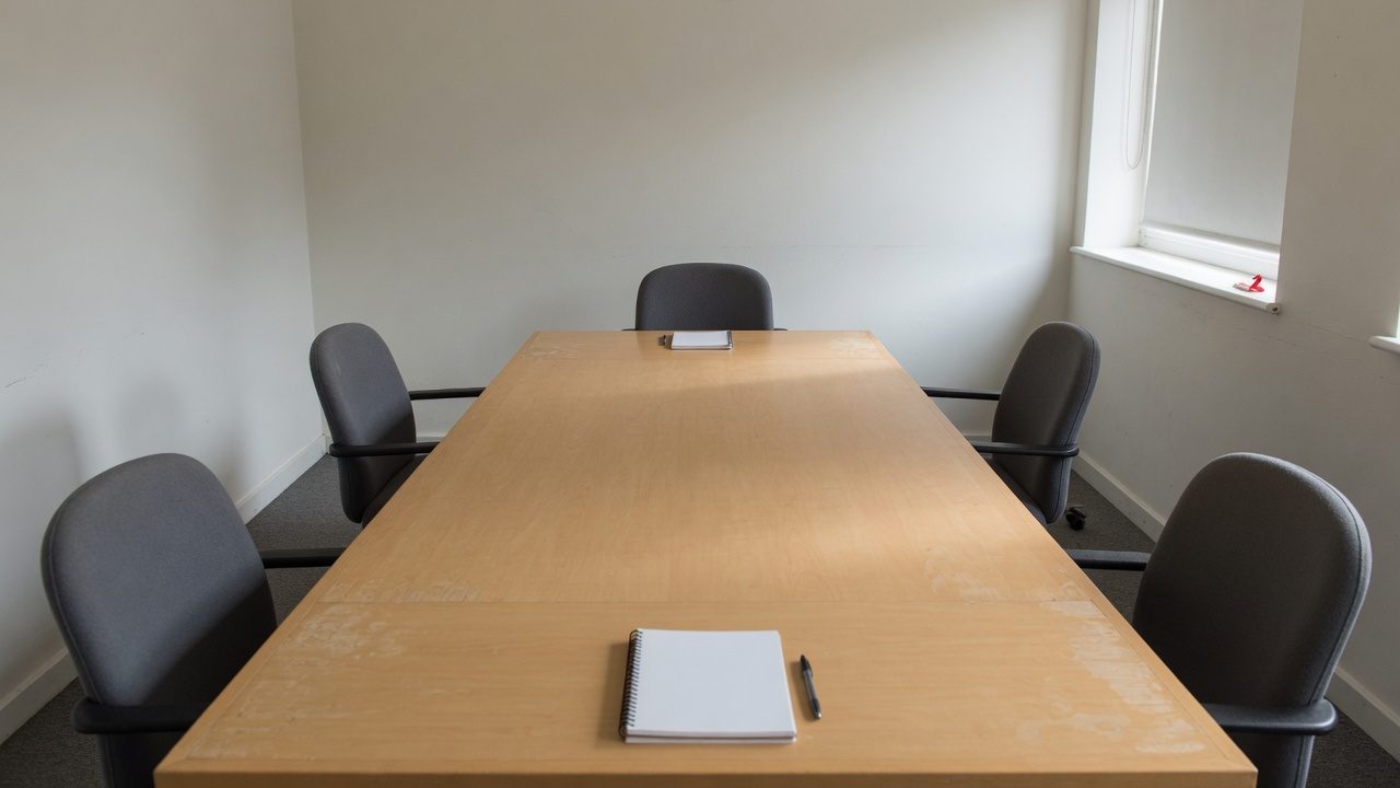 Mesa de reunião longa com dois lugares postos em pontas opostas
